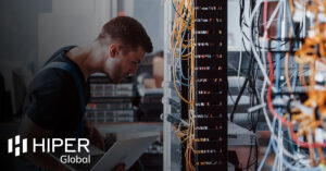 A man working on a server rack, ensuring it's been engineered correctly - including the HIPER Global logo
