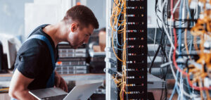 A man working on a server rack, ensuring it's been engineered correctly