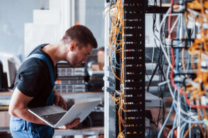 A man working on a server rack, ensuring it's been engineered correctly