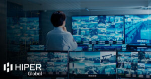 A data engineer monitoring a CCTV video wall control room through AV over IP technology - including the HIPER Global logo