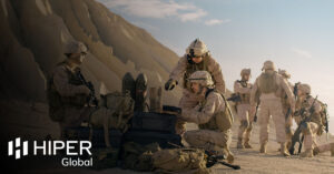 A unit of soldiers in the desert using rugged hardware to contact their base - including the HIPER Global logo