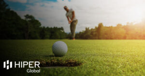 A golf player putting a golf ball into hole, tracked by optical tracking technology - including the HIPER Global logo